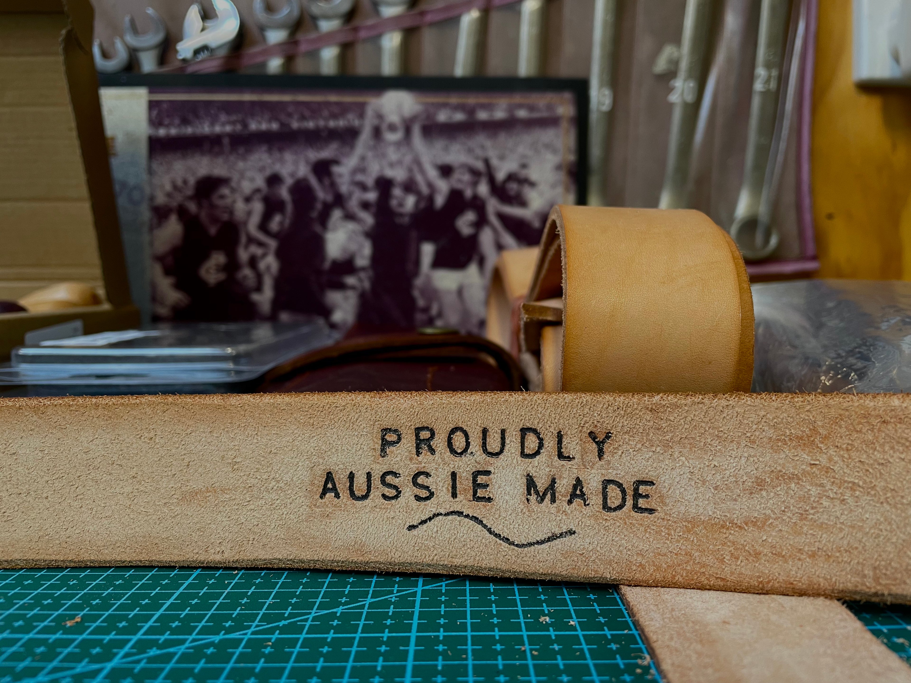 Leather strap with 'PROUDLY AUSSIE MADE' text, featuring a photo of Carlton Football Club celebrating premiership in the background.